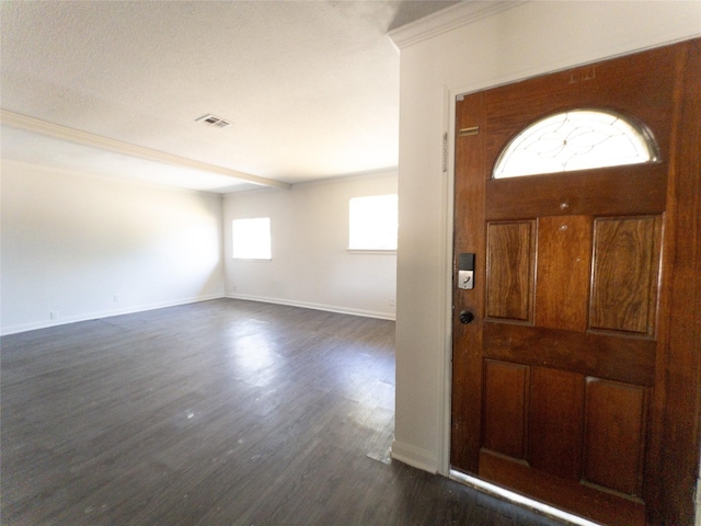 foyer entrance featuring dark wood-type flooring and ornamental molding