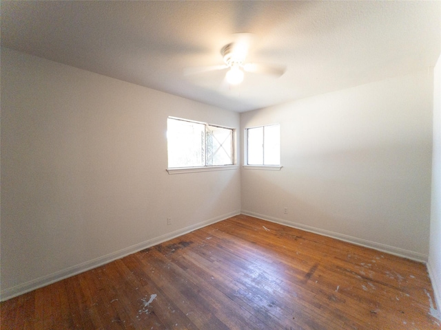 unfurnished room with ceiling fan and dark hardwood / wood-style flooring