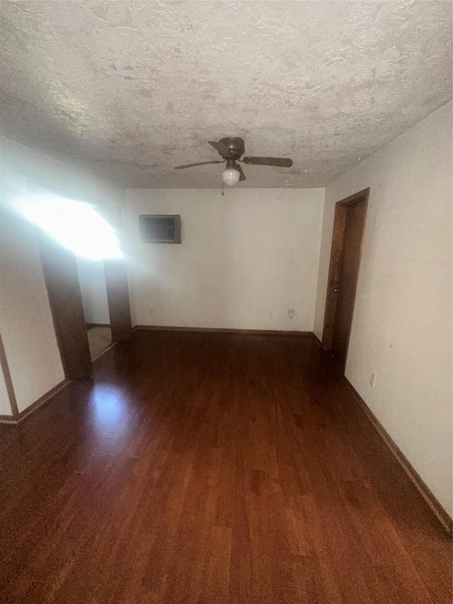 spare room with dark wood-type flooring, ceiling fan, and a textured ceiling