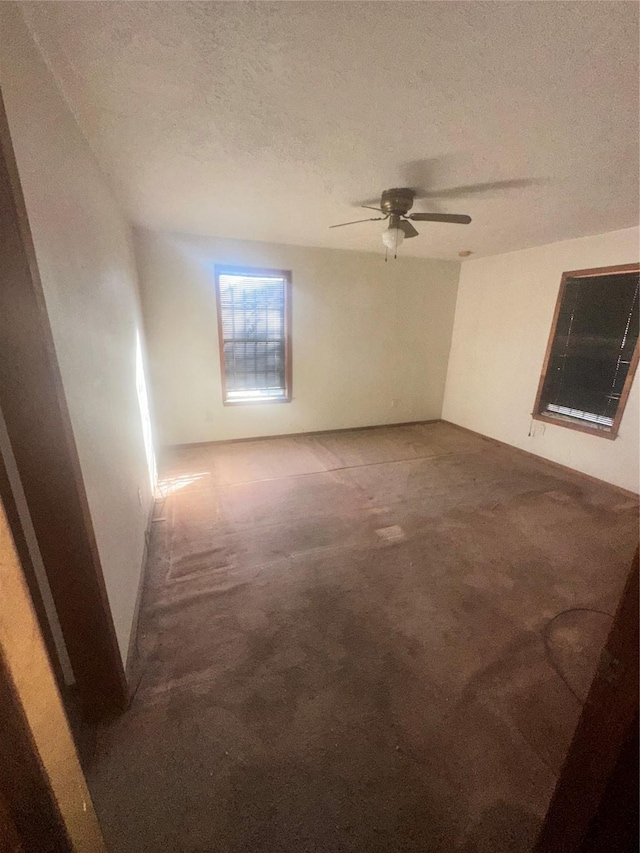 unfurnished room with ceiling fan, carpet floors, and a textured ceiling