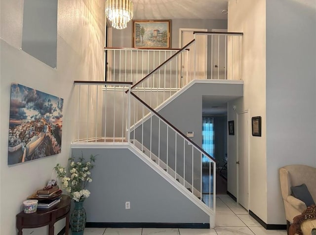 stairway with a notable chandelier and a high ceiling