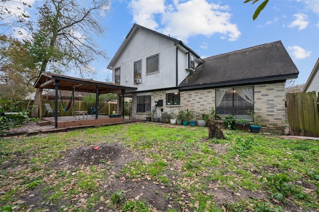 back of house featuring a wooden deck and a lawn