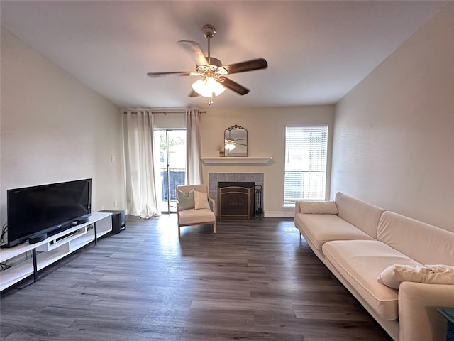 living room with ceiling fan, dark hardwood / wood-style flooring, a healthy amount of sunlight, and a fireplace