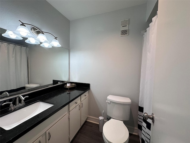 bathroom featuring toilet, vanity, and hardwood / wood-style floors