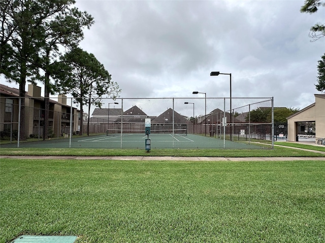 view of sport court with a lawn