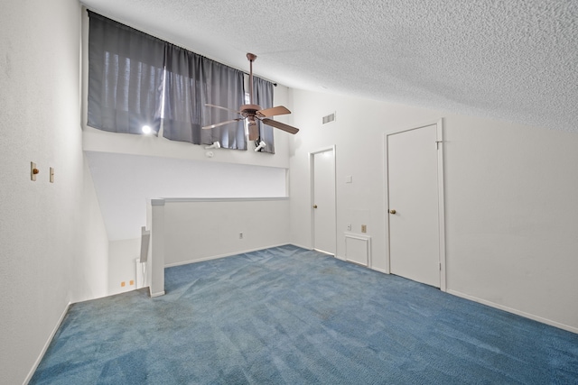 unfurnished living room with ceiling fan, a textured ceiling, lofted ceiling, and carpet flooring