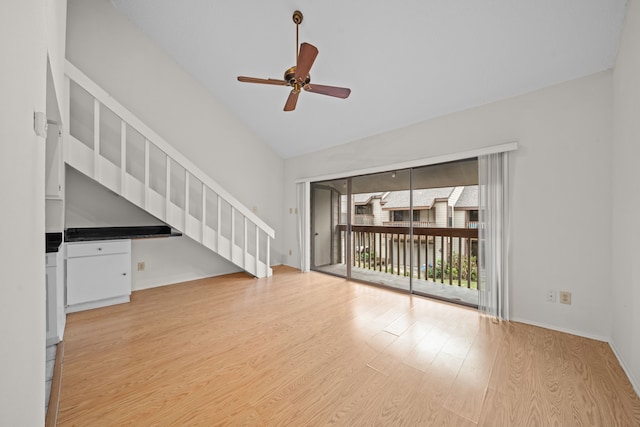 unfurnished living room with ceiling fan, vaulted ceiling, and light hardwood / wood-style flooring