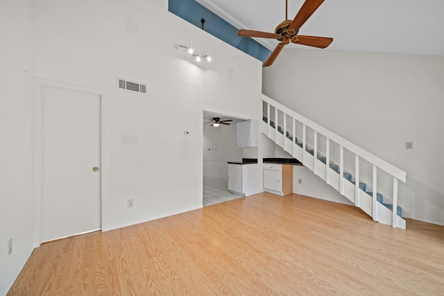 unfurnished living room featuring high vaulted ceiling and light wood-type flooring