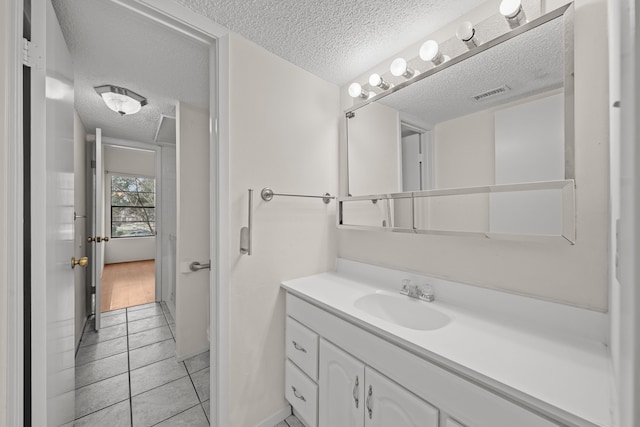 bathroom featuring a textured ceiling, tile patterned floors, and vanity