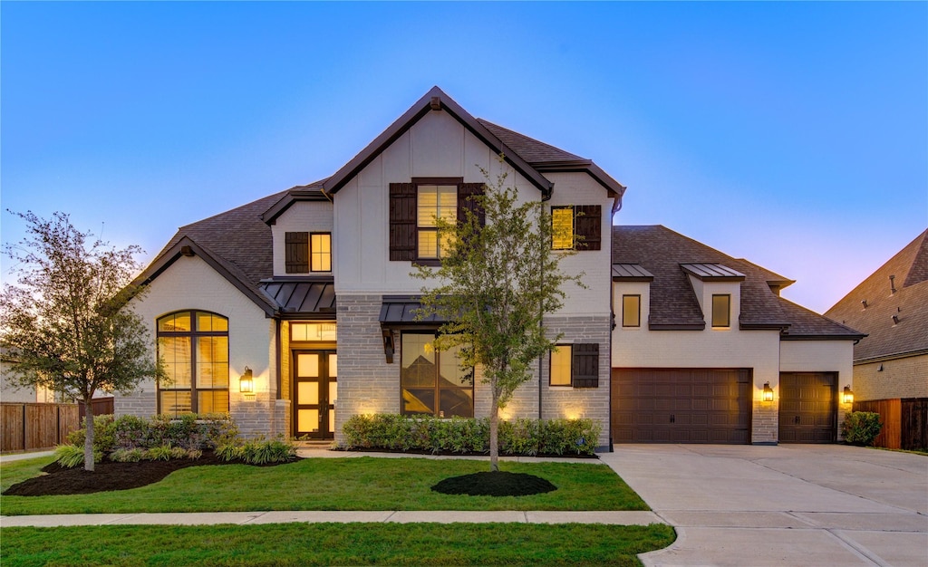 view of front of home with a garage and a yard