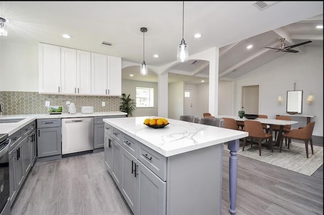 kitchen with appliances with stainless steel finishes, decorative light fixtures, white cabinetry, lofted ceiling with beams, and gray cabinetry