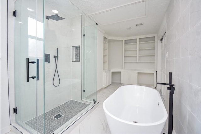 bathroom featuring a textured ceiling, shower with separate bathtub, tile walls, and built in shelves