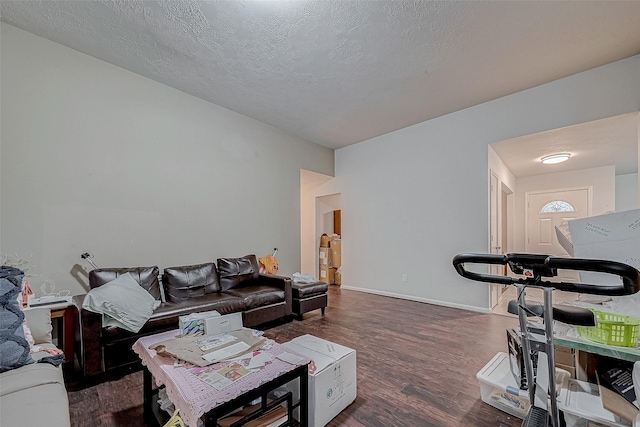 living room with dark hardwood / wood-style floors and a textured ceiling