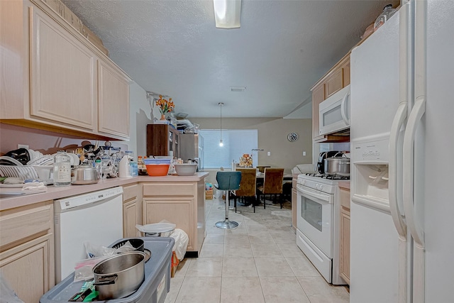 kitchen featuring decorative light fixtures, light brown cabinetry, and white appliances