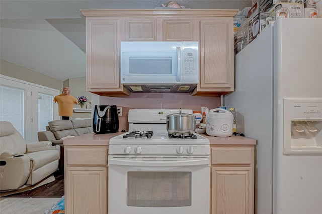 kitchen with light brown cabinets and white appliances