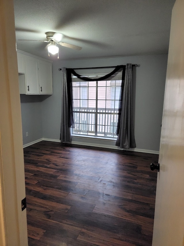 unfurnished room featuring dark hardwood / wood-style floors and ceiling fan