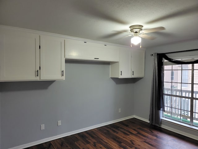 spare room with ceiling fan, a healthy amount of sunlight, dark hardwood / wood-style flooring, and a textured ceiling