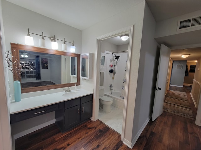 full bathroom featuring vanity, hardwood / wood-style flooring, toilet, and washtub / shower combination