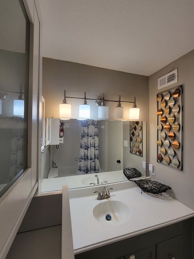 bathroom featuring shower / bath combo, sink, and a textured ceiling