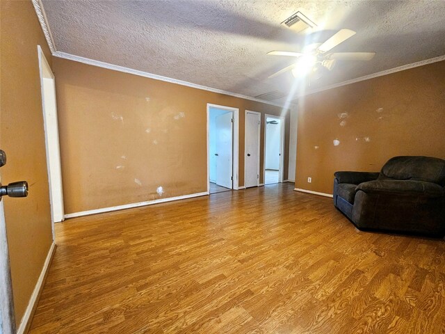 living room featuring crown molding, a textured ceiling, and light hardwood / wood-style floors