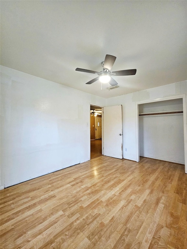 unfurnished bedroom with ceiling fan, a closet, and light hardwood / wood-style flooring