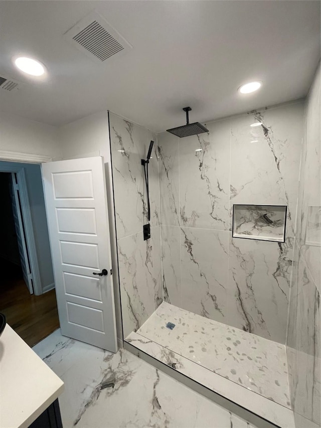 bathroom with vanity and tiled shower