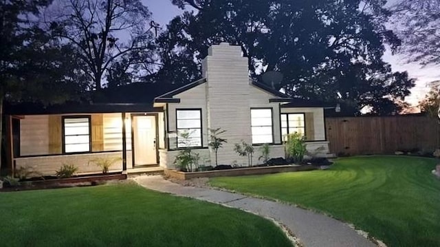 view of front of property featuring a lawn