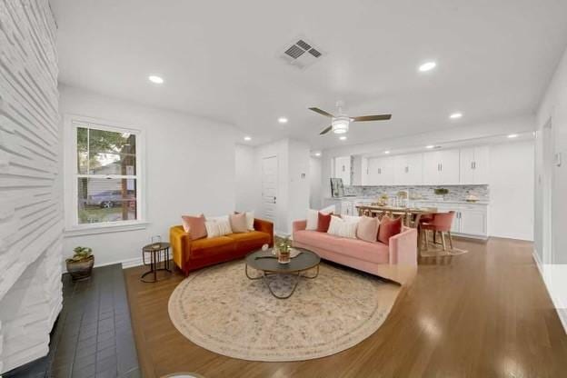 living room with dark wood-type flooring and ceiling fan