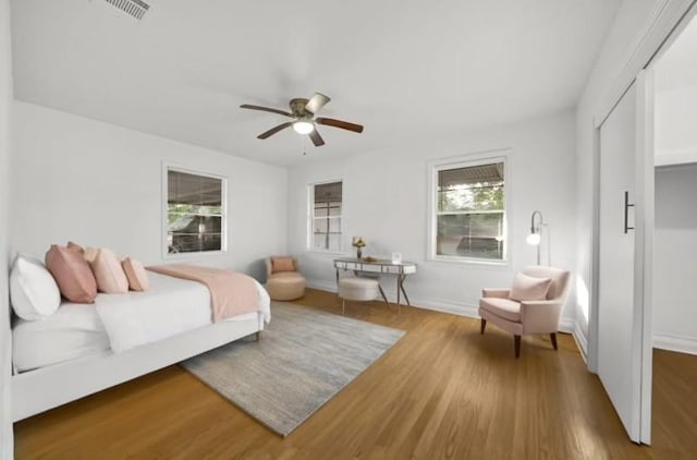 bedroom with ceiling fan, hardwood / wood-style floors, and a closet