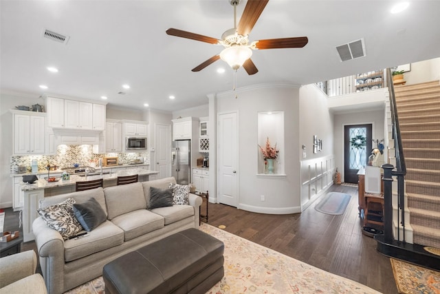 living room featuring crown molding, ceiling fan, and dark hardwood / wood-style flooring