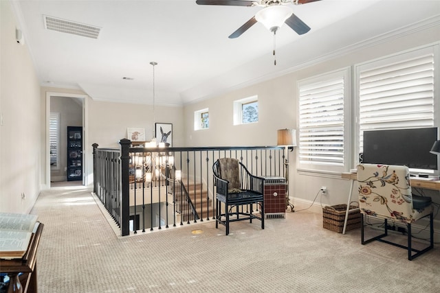 sitting room featuring crown molding, ceiling fan with notable chandelier, and light colored carpet