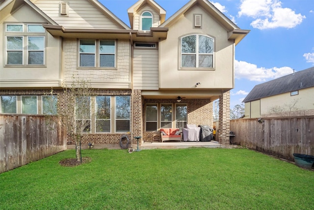 back of house featuring ceiling fan, a patio area, and a lawn