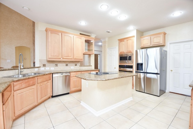 kitchen featuring appliances with stainless steel finishes, light brown cabinets, light stone counters, and sink