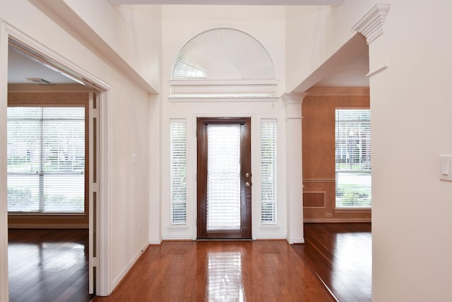 entryway with dark hardwood / wood-style floors and ornate columns