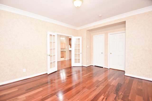 spare room featuring wood-type flooring, ornamental molding, and french doors