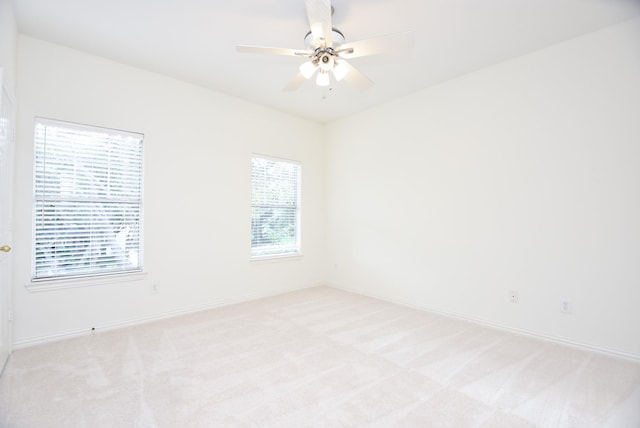 spare room with ceiling fan and light colored carpet