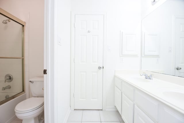 full bathroom with toilet, bath / shower combo with glass door, tile patterned flooring, and vanity