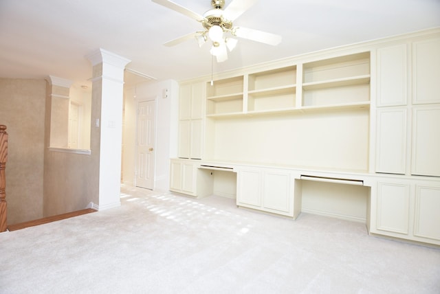 interior space with ceiling fan, built in desk, and light colored carpet