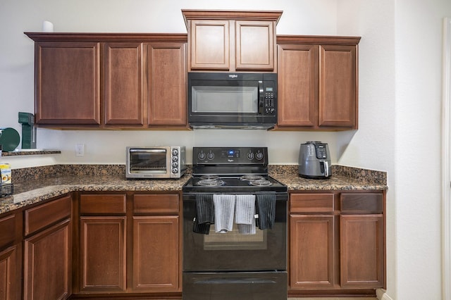 kitchen with black appliances and dark stone countertops