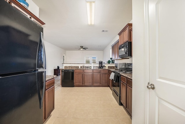 kitchen with sink, ceiling fan, dark stone countertops, and black appliances