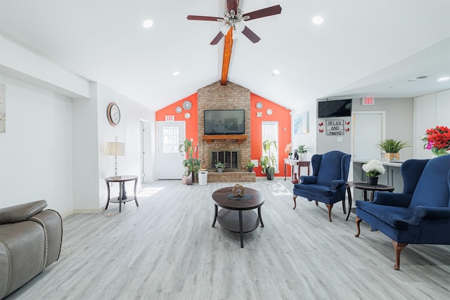 living room featuring lofted ceiling with beams, ceiling fan, a fireplace, and light hardwood / wood-style flooring