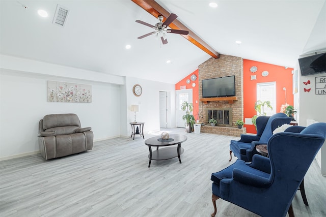 living room featuring ceiling fan, a fireplace, light hardwood / wood-style floors, and vaulted ceiling with beams