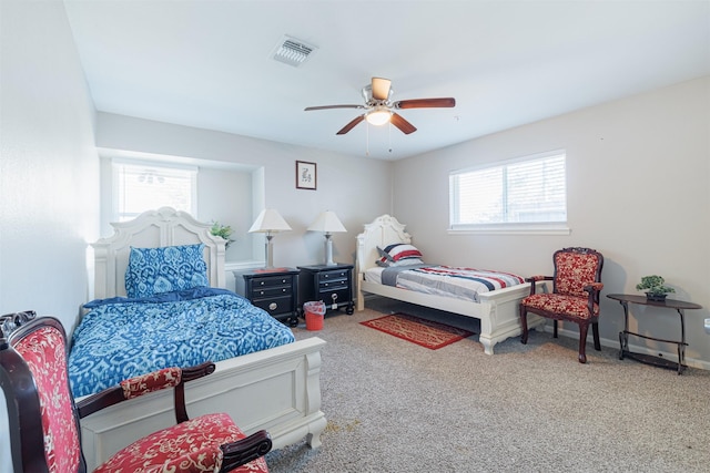 bedroom with multiple windows, ceiling fan, and carpet