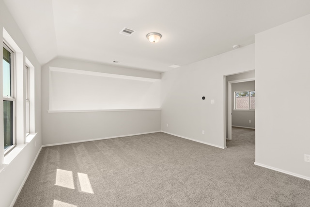 empty room featuring carpet floors and vaulted ceiling