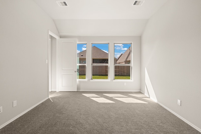 spare room featuring lofted ceiling and carpet flooring