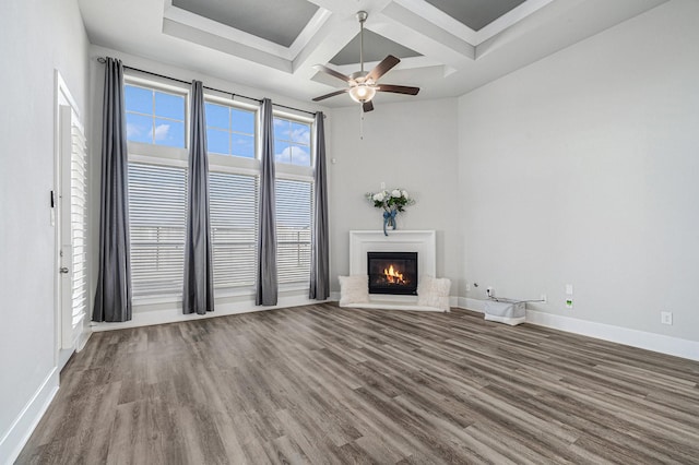 unfurnished living room with ceiling fan, wood-type flooring, beam ceiling, and coffered ceiling