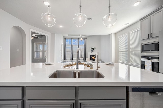 kitchen with sink, decorative light fixtures, gray cabinetry, and appliances with stainless steel finishes