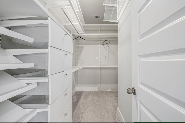 walk in closet featuring light colored carpet