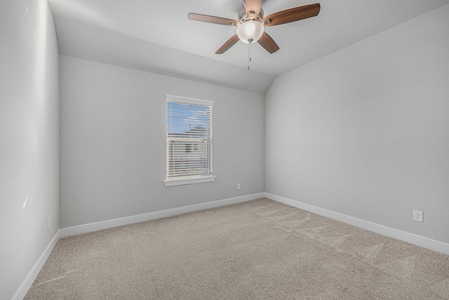 carpeted spare room featuring ceiling fan and lofted ceiling