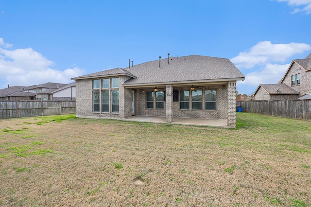 rear view of property with a lawn and a patio